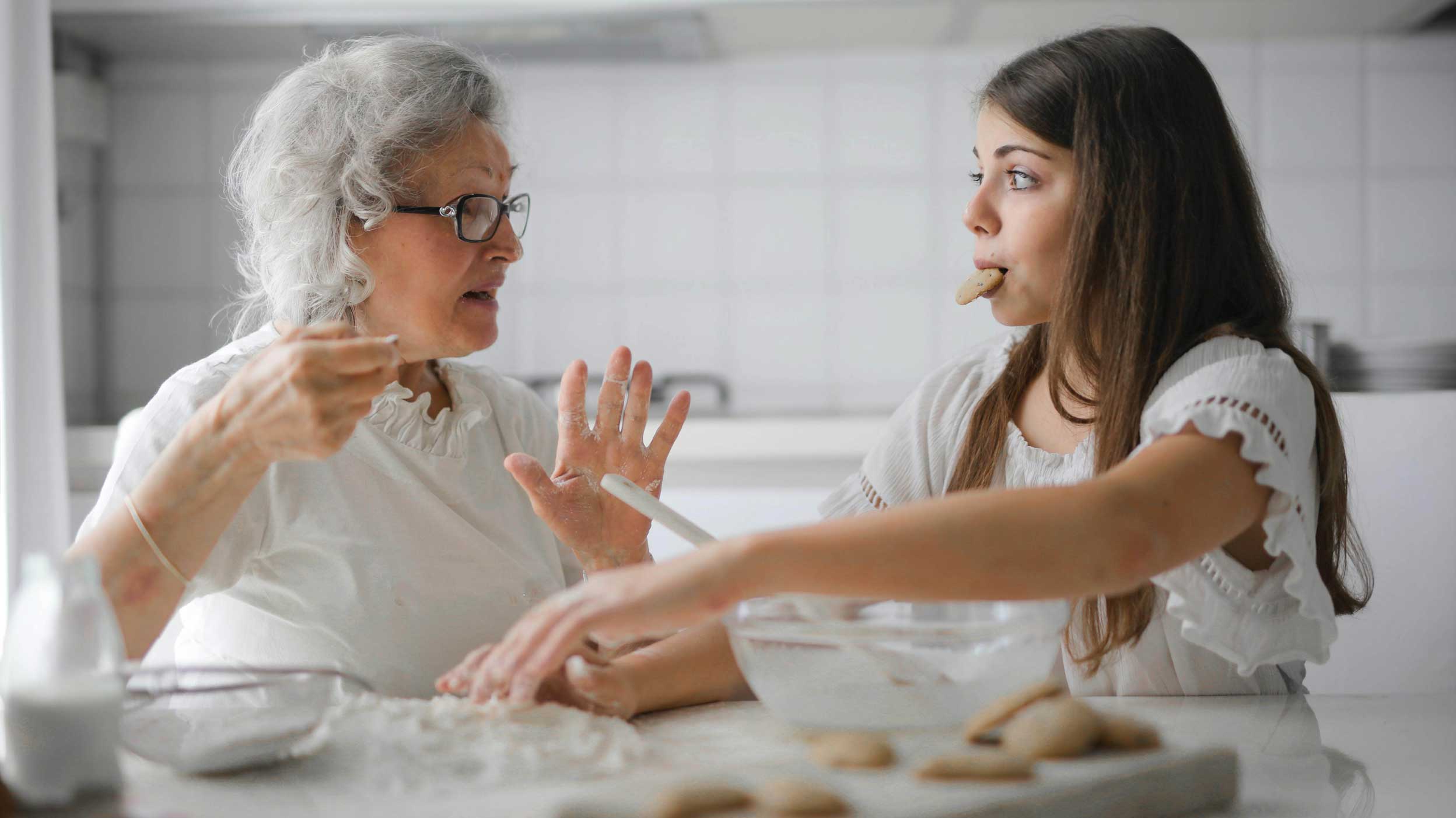 Grandmother and granddaughter baking cookies in the kitchen